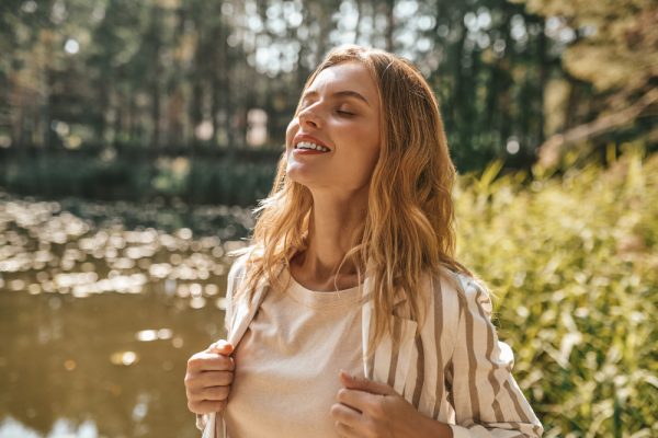 Woman enjoying nature and relaxation as a symbol of stress recovery and wellness.
